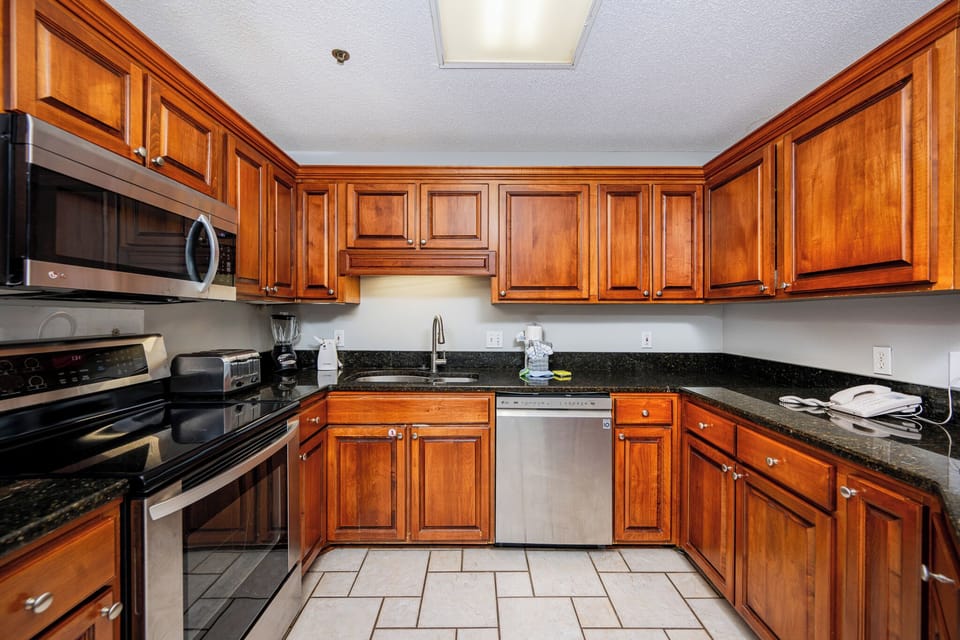 The kitchen features rich wooden cabinets, sleek countertops, and stainless appliances for a seamless cooking experience