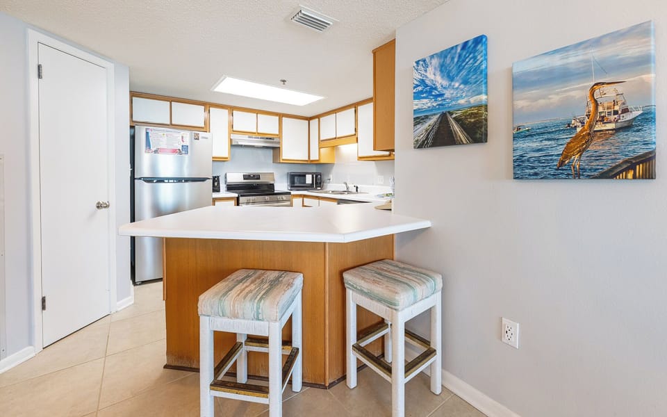 Gather at the cozy bar stools, enjoying a casual chat while sipping your favorite drink in this inviting kitchen space