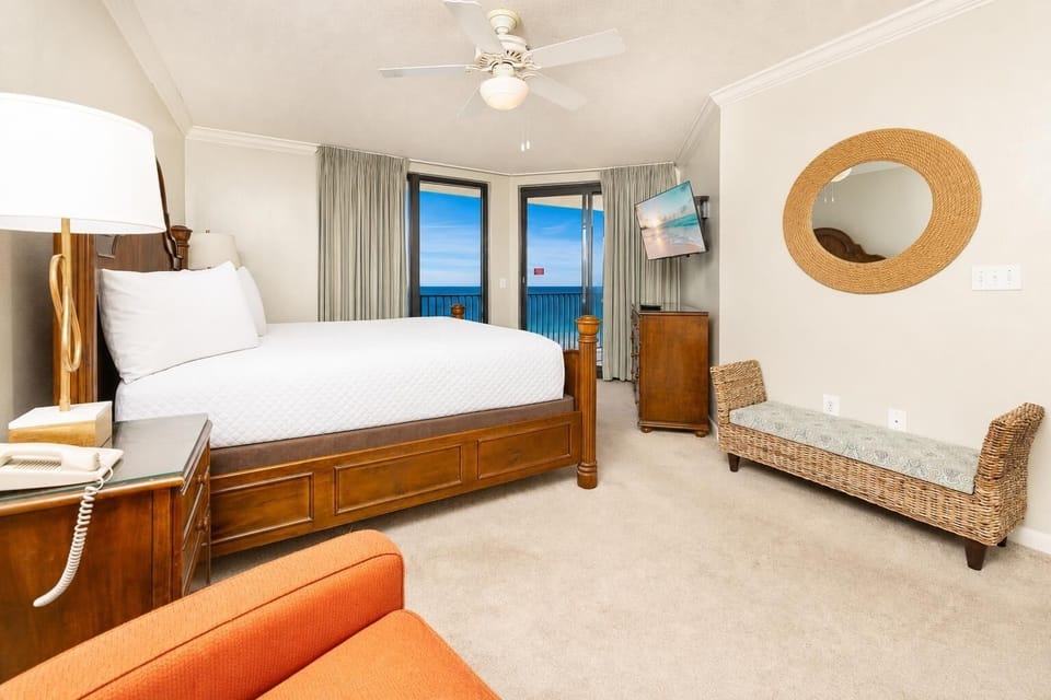 The king bed in the master suite faces glass doors opening to your balcony with calming coastal views