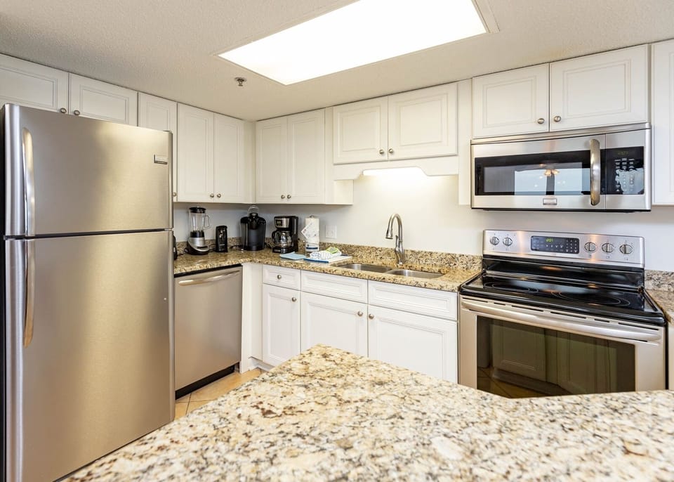 Modern kitchen features granite countertops, sleek cabinetry, and stainless appliances for a convenient cooking experience