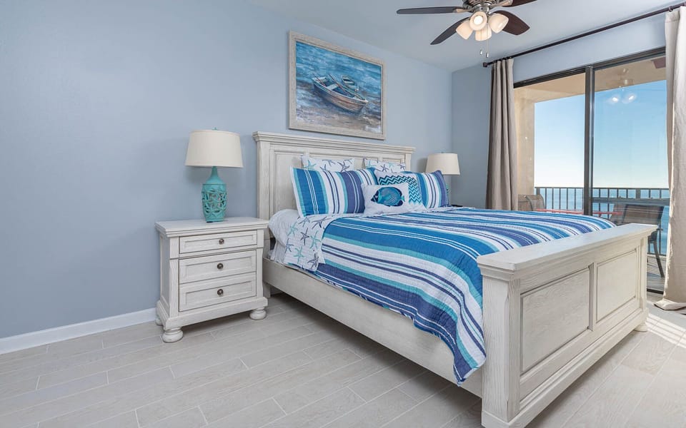 Serene master suite featuring a stylish king bed, coastal decor, and beachfront balcony access