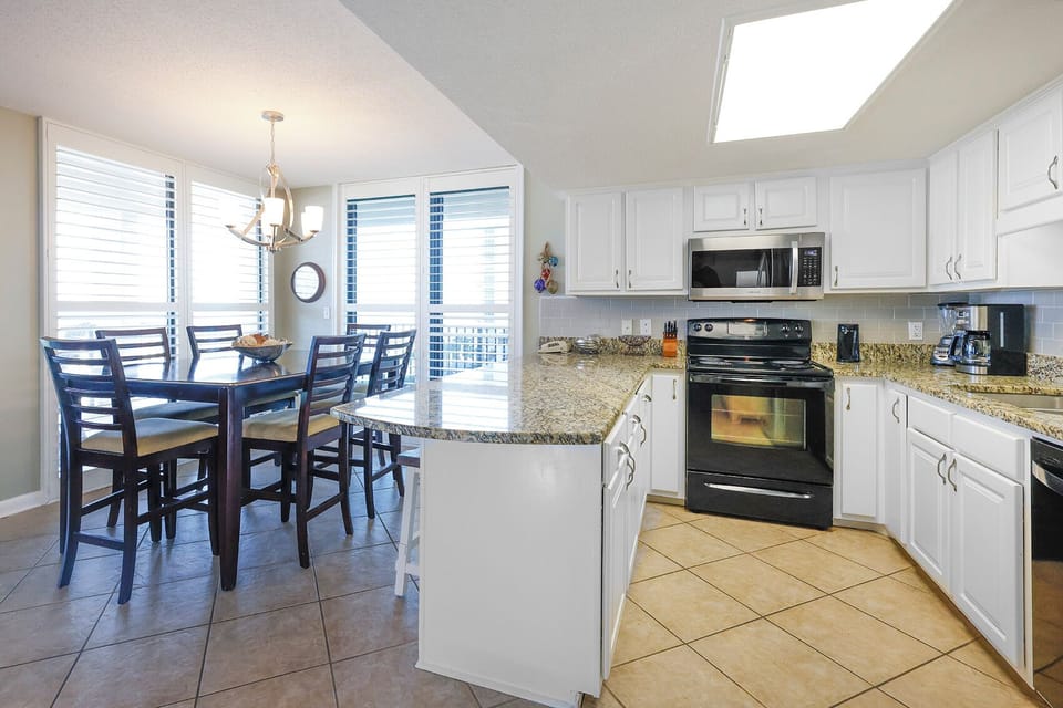 Enjoy meals and family gatherings in this kitchen and dining area with a beachfront view