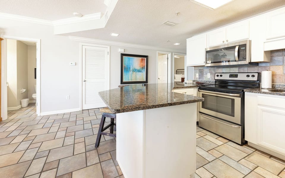 Smooth granite breakfast bar invites casual mornings and shared stories in the open kitchen space