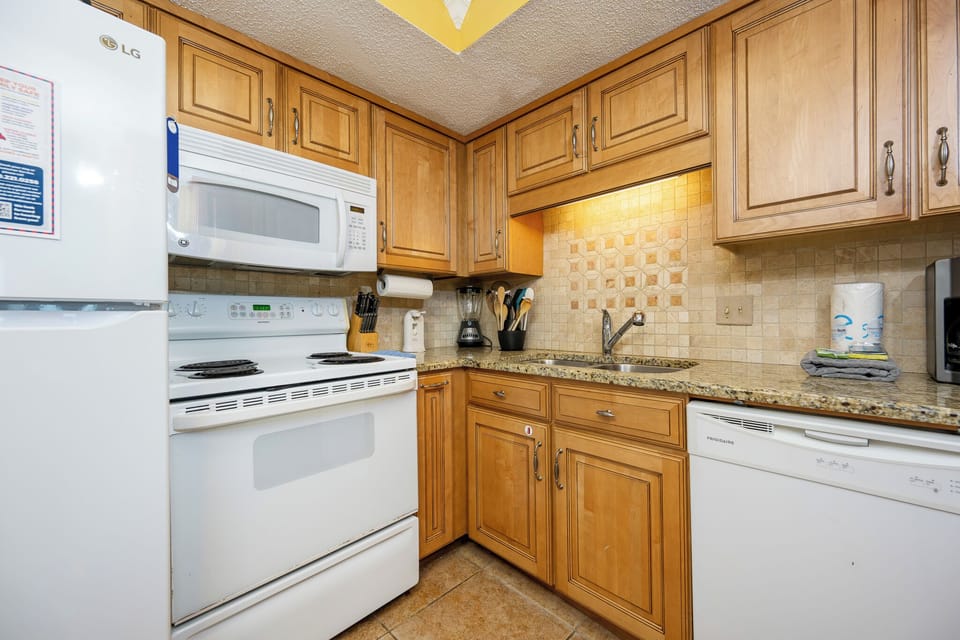 Unleash your culinary creativity in this inviting kitchen, complete with essential appliances and warm wood cabinetry