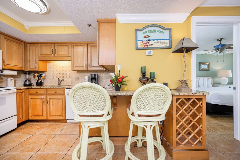 Enjoy a refreshing drink at the bar stools, surrounded by a cozy kitchen vibe and inviting decor just steps from your getaway