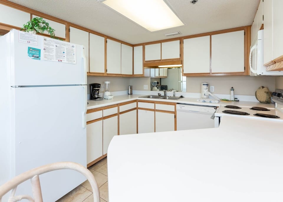 The fully-equipped kitchen features white cabinetry, a breakfast bar, and essential appliances for convenient meal prep