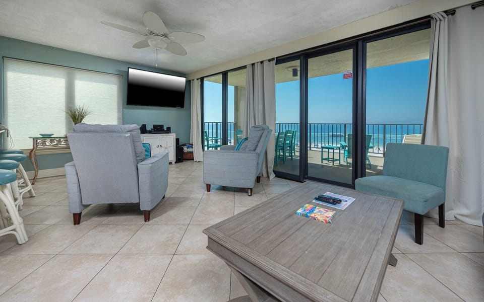 This living area features cozy seating, a queen sofa-sleeper, large TV, and a breathtaking view of the beach