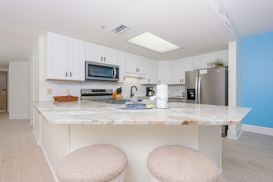 Prepare meals in the bright kitchen featuring stainless steel appliances and a spacious countertop for dining or gathering