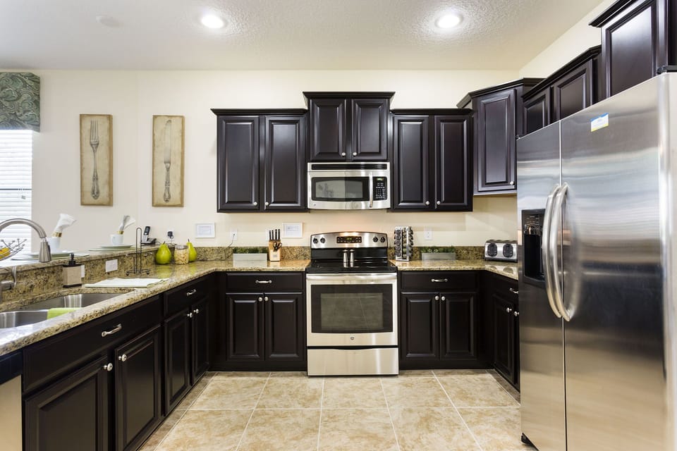 The fully-equipped kitchen features stainless steel appliances and granite countertop