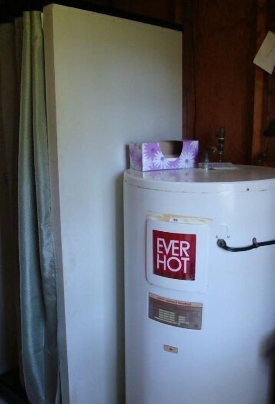 Large hot water tank in bathroom.