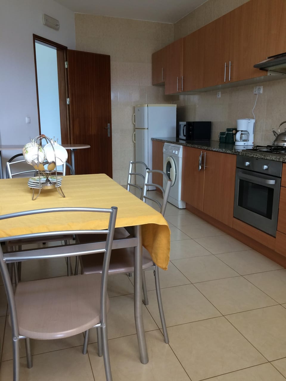 Full kitchen with stove, refrigerator, microwave, coffee maker, tea kettle, and 