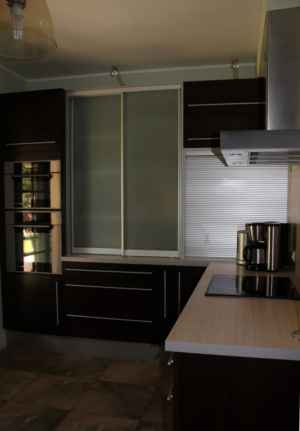 Kitchen: hob, coffee machine, oven, microwave and crockery store