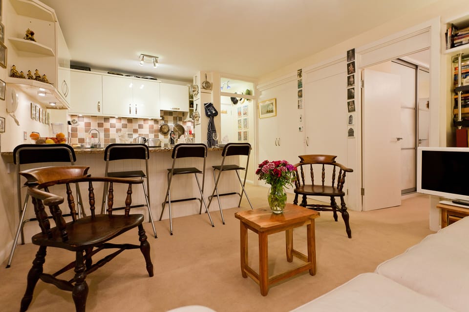 Living room: breakfast bar and kitchen; entrance door; right door to bedroom