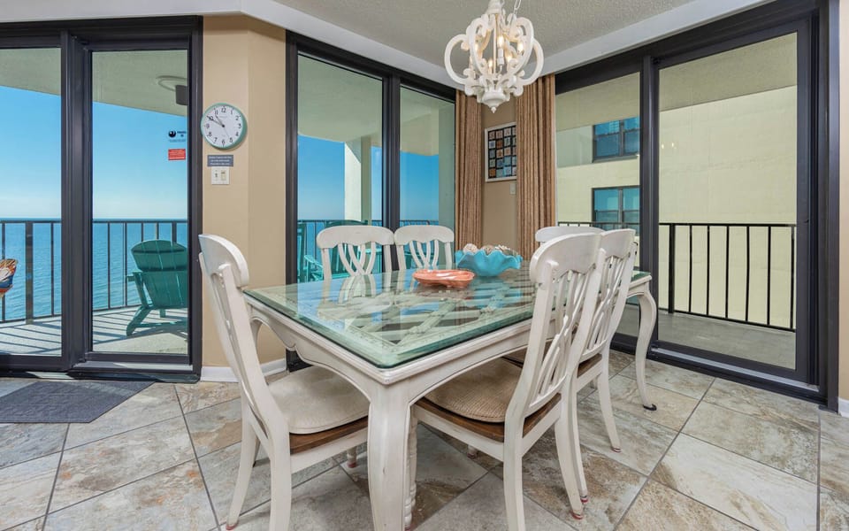 Bright dining room glass table invites your family to share stories beside the gulf coast view