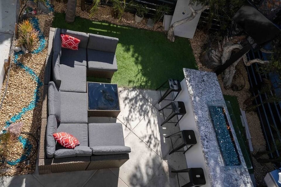 Remodeled patio with fire pit couch and grill