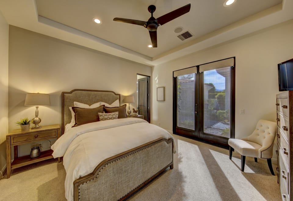Guest bedroom 2 with queen bed, en suite bath, TV and direct access to front private courtyard.