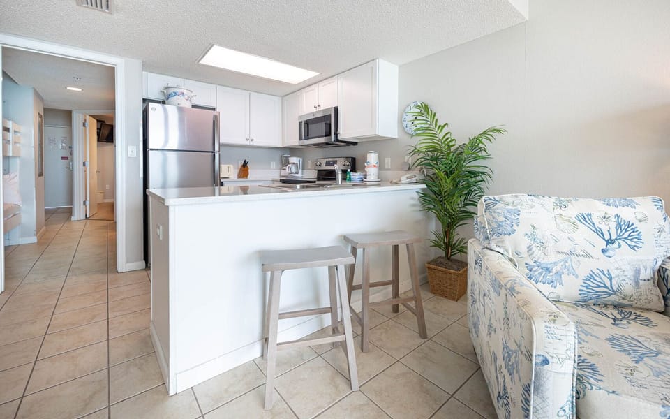 Enjoy cooking and dining at the breakfast bar, surrounded by a bright, inviting kitchen and coastal decor