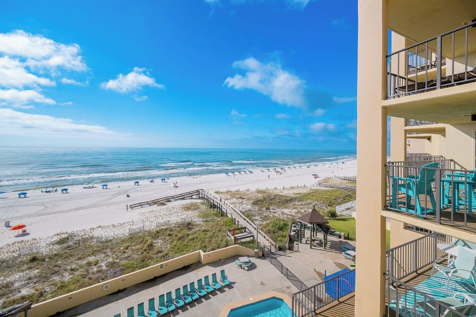 Enjoy stunning views from your balcony overlooking the pristine beach and inviting pool area, perfect for relaxation
