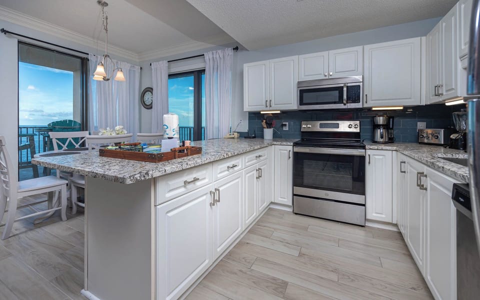 Enjoy cooking in this stylish kitchen with stainless appliances, granite counters, and a beachfront view