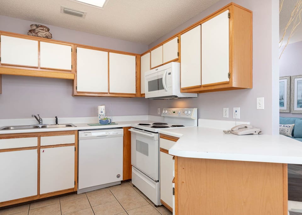 Kitchen features white cabinetry, a double sink, and a convenient layout, perfect for preparing meals during your stay