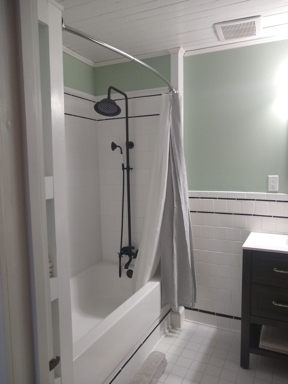 Classic black and white bathroom with tub and shower.