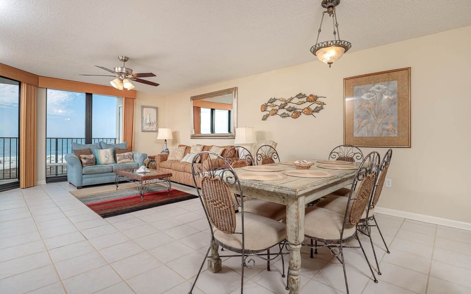 Bright living area features a cozy sofas with a queen sleeper, decorative accents, and a dining table with stylish chairs