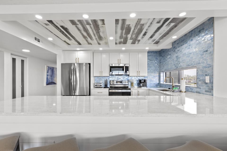 Sleek modern open kitchen with sparkling quartz countertops and stainless steel appliances