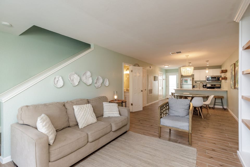 Sink into the plush sofa and feel instantly at home in this bright, coastal-inspired living space with your open kitchen nearby.