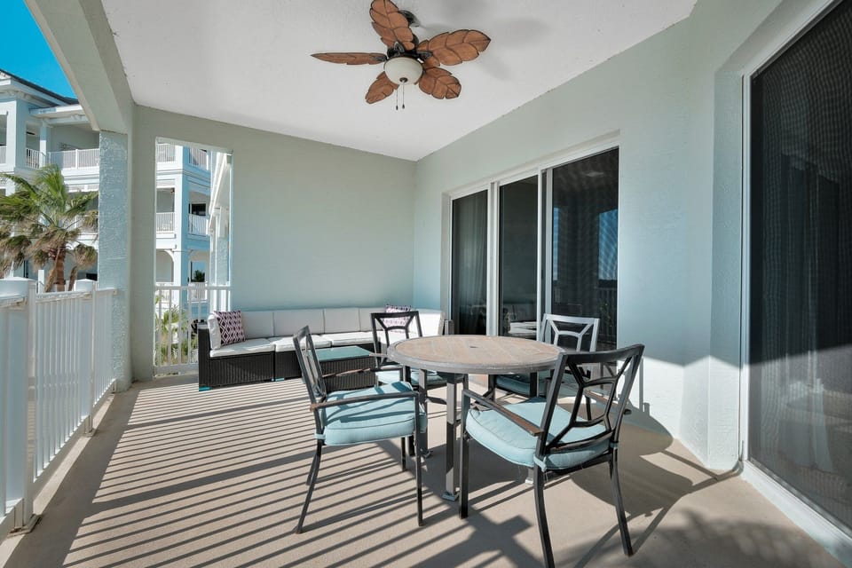 Spacious balcony featuring a table, chairs, and a comfortable couch