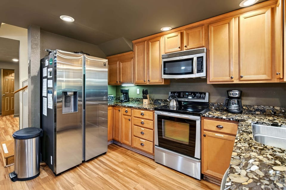 Updated galley-style kitchen with stainless steel appliances, a dishwasher, and two drip-style coffeemakers.