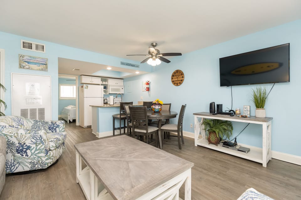 Your bright, coastal-themed living space flows seamlessly from living room to kitchen, perfect for relaxing with tropical-inspired furnishings and modern amenities.
