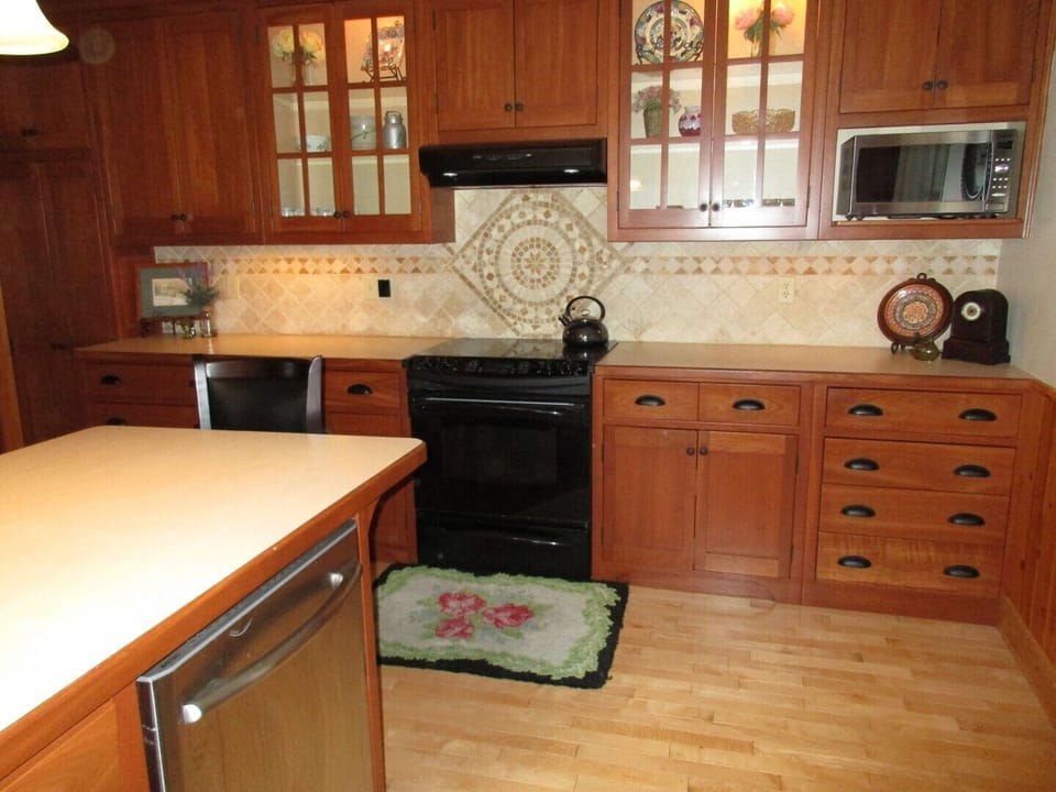 The modern kitchen includes stove, fridge, microwave and dishwasher.