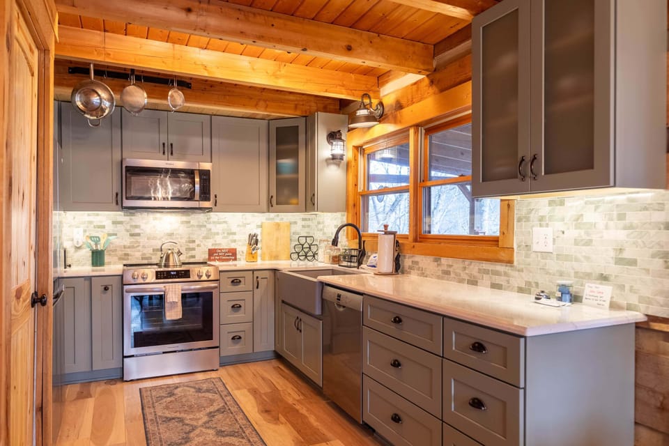 A fully equipped kitchen ready for mountain meals, with warm wood beams overhead and plenty of counter space to gather around.