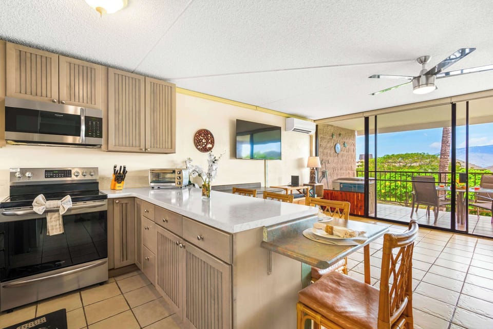 Enjoy the ultimate open-concept layout og your unit, where a fully equipped kitchen seamlessly connects to a sunlit dining area and scenic outdoor lanai.