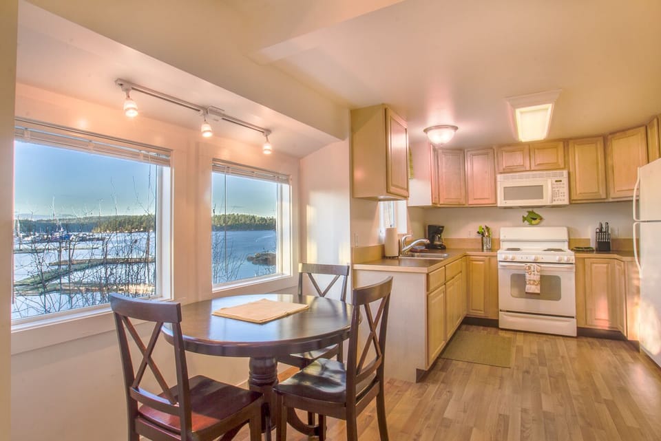 Interior dining table and kitchen both have water views.