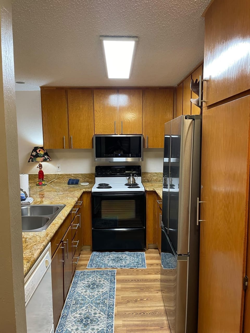 Full kitchen with large granite countertop and bar stools