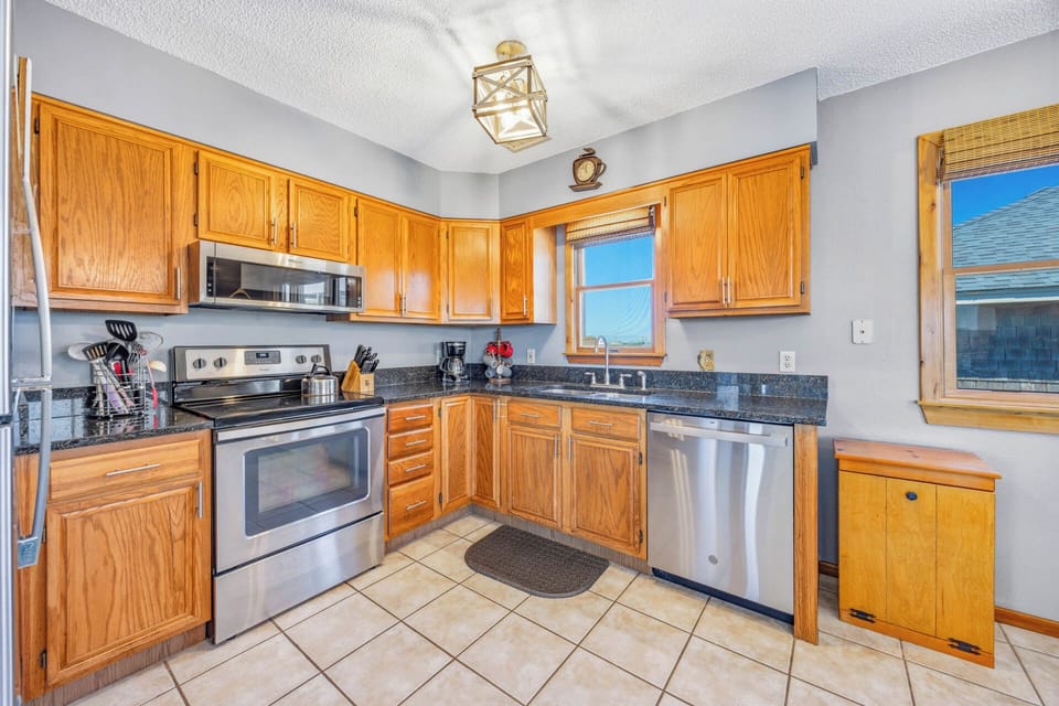 Prepare your favorite meals in this fully-equipped kitchen with stainless steel appliances, granite countertops, and warm oak cabinetry—everything you need for a home-cooked vacation feast.
