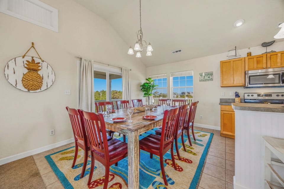 Gather everyone around this spacious dining table where your group can share meals, laughter, and stories. Natural light pours through the windows, and the cheerful coastal décor sets the perfect vacation tone.