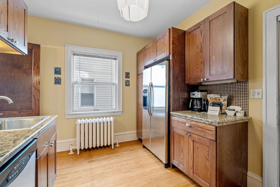 Your fully-equipped kitchen features rich wooden cabinets and granite countertops, with modern stainless appliances ready for your culinary adventures.