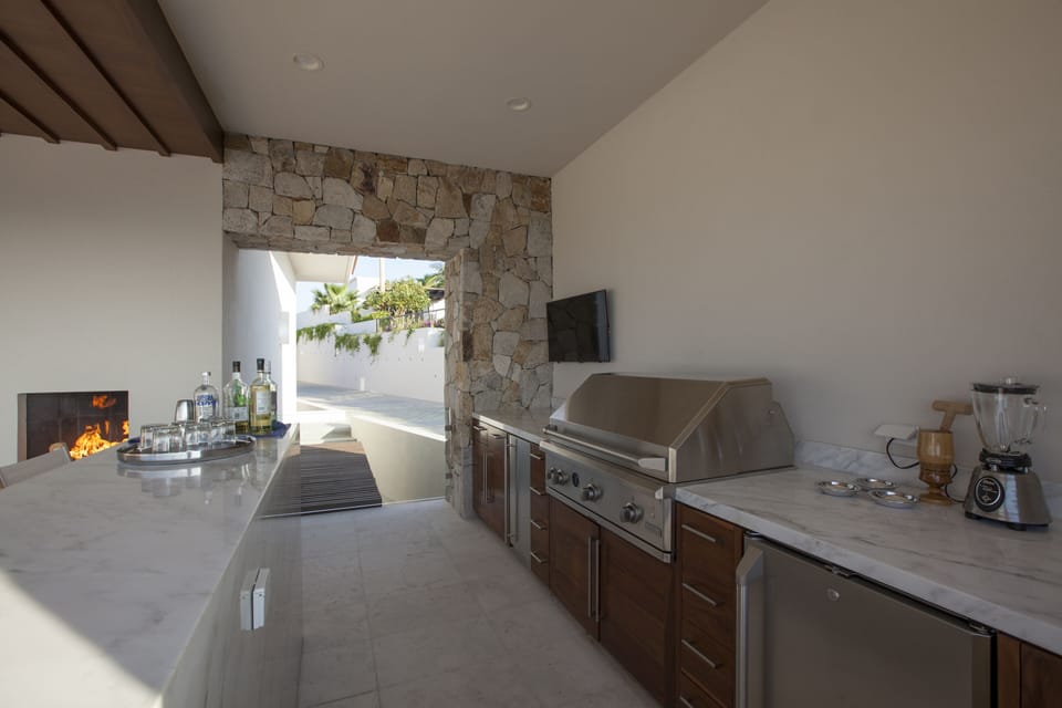 Marble Pool bar with BBQ, Rotisserie, Ice Maker, Beverage fridge and TV.