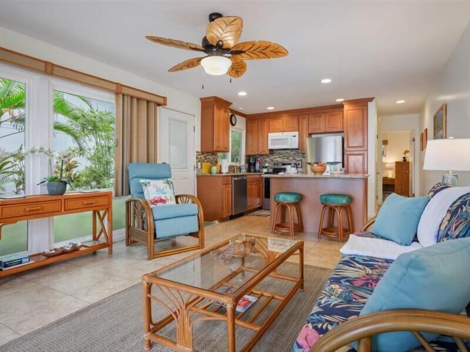 Relax and unwind in this bright, airy living area - Inviting open-concept living space with tropical décor, comfortable seating, and a modern kitchen perfect for island living.