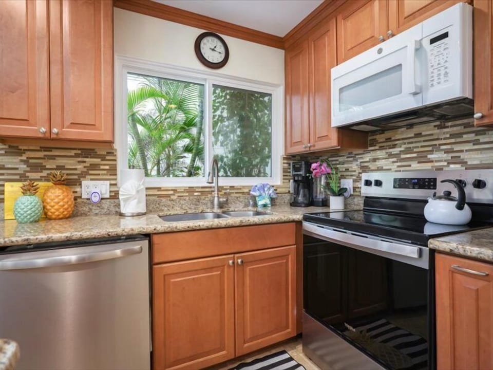 Prepare meals with ease in this fully equipped kitchen - Well-equipped kitchen with granite counters, stainless steel appliances, and tropical views just outside the window.