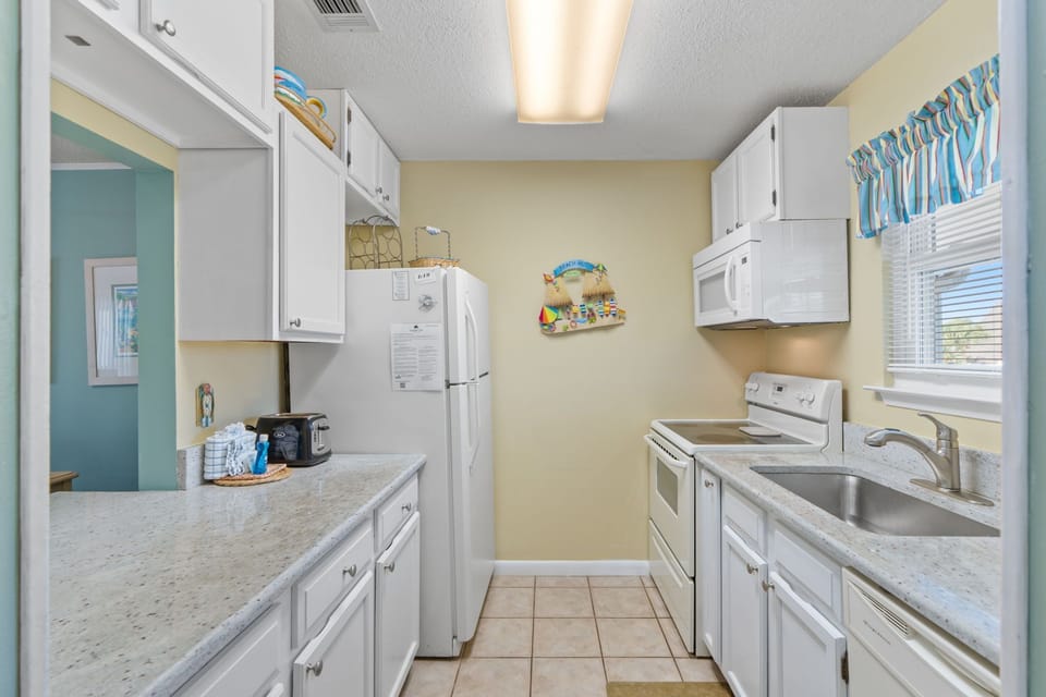 Your fully equipped kitchen makes vacation cooking a breeze with modern appliances and coastal-themed touches throughout.