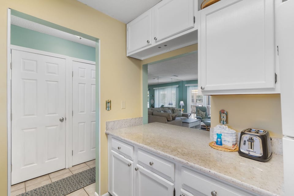 Your bright kitchen features granite counters and modern appliances, perfect for morning coffee before enjoying the spacious living area beyond.