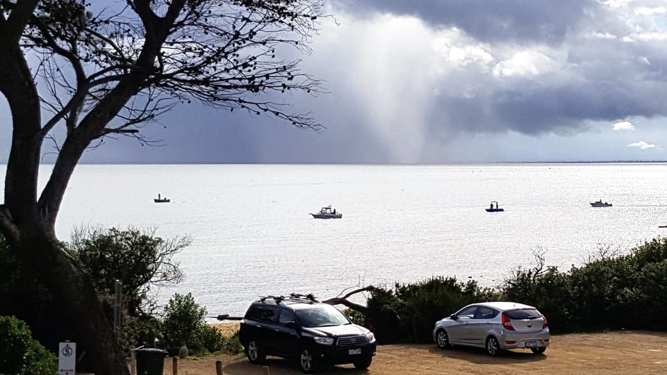 View of storm in Melbourne. while sunny in Mornington. 
