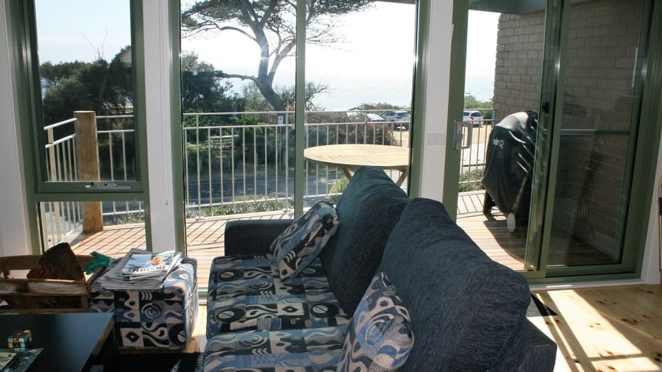Upstairs lounge and view of balcony. Weber BBQ on balcony. Outdoor table + chrs.