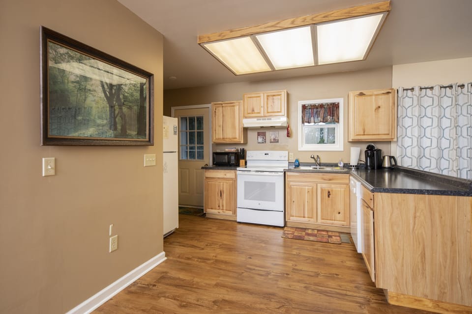 fully equipped kitchen with door leading to back deck