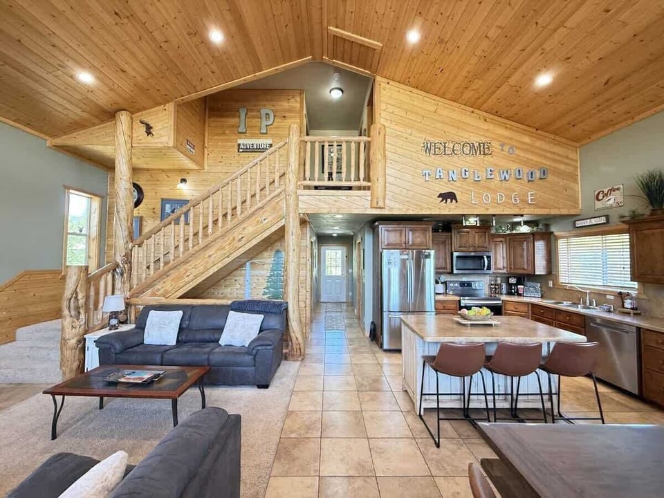 Access to the third level is up the stairs. The open kitchen blends seamlessly into the cabin's cozy living area, creating a welcoming space perfect for gathering and unwinding.