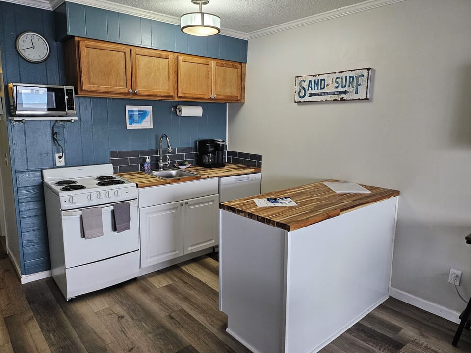Kitchen with microwave, dishwasher, stove, and full-size refrigerator. 