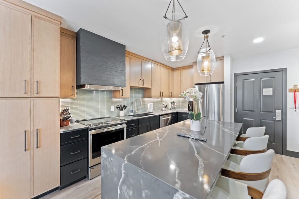 Full kitchen featuring stainless steel appliances and a breakfast bar with seating for four.